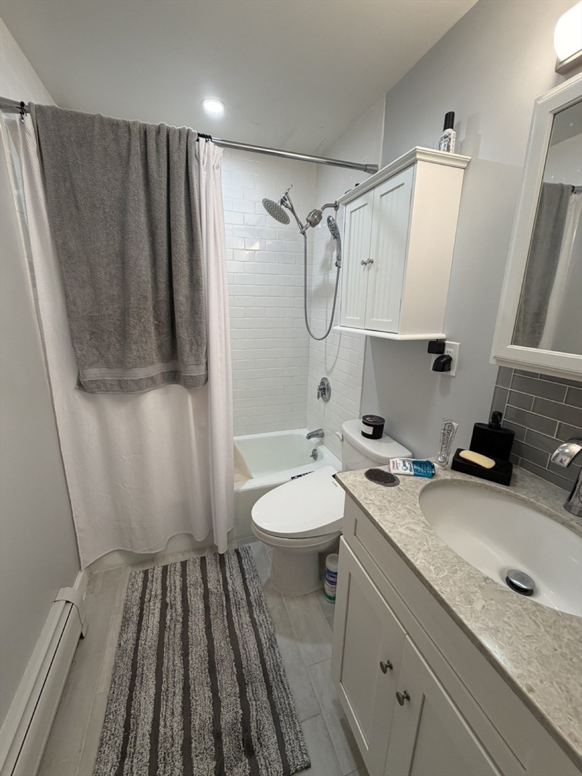 Renovated apartment bathroom with a subway-tile tub surround