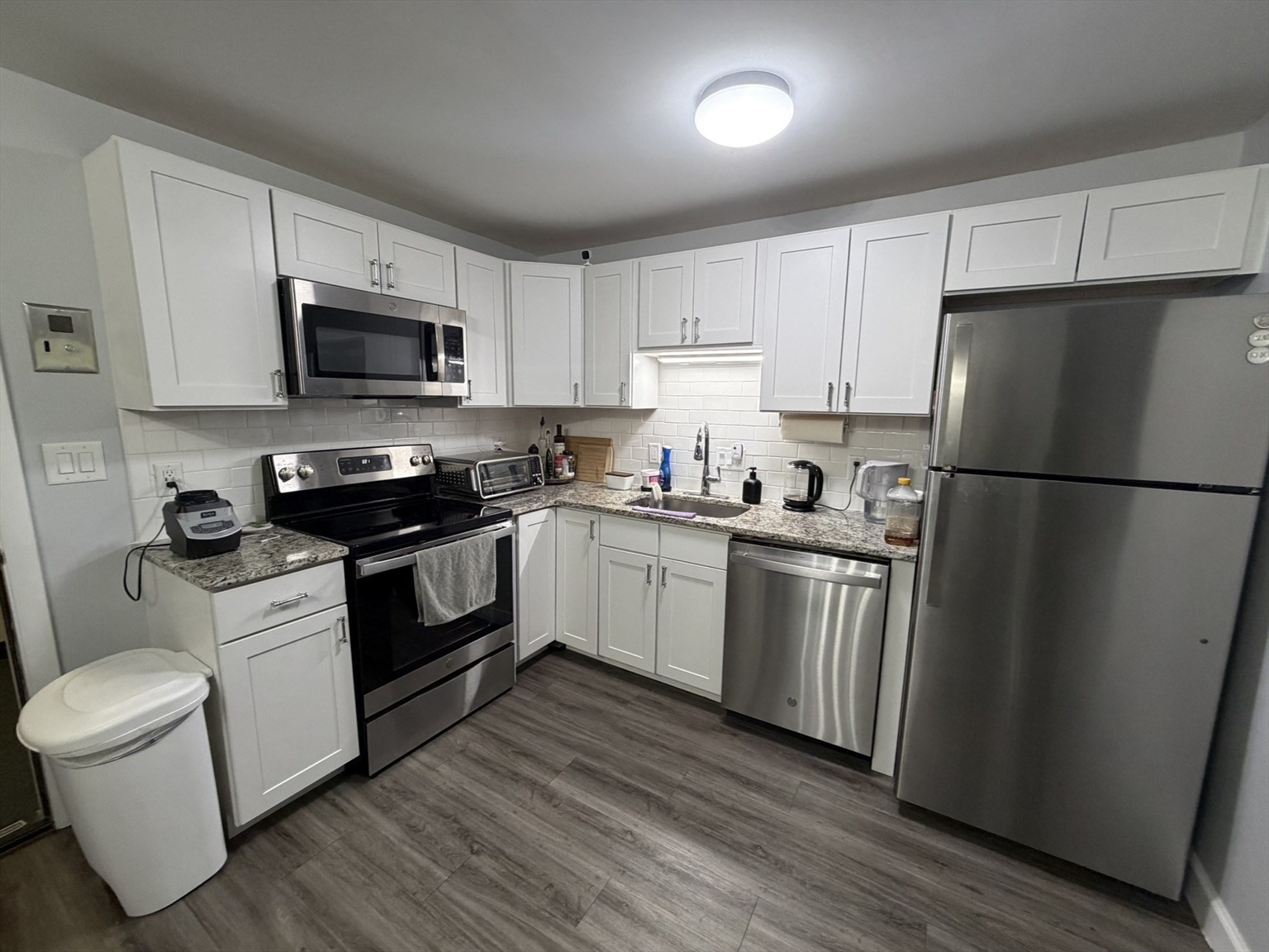 Renovated apartment kitchen with stone counters and stainless appliances